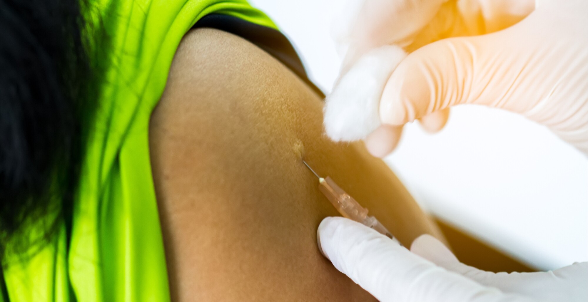 Picture of doctor inserting needle into arm of patient with shirt sleeve rolled up.